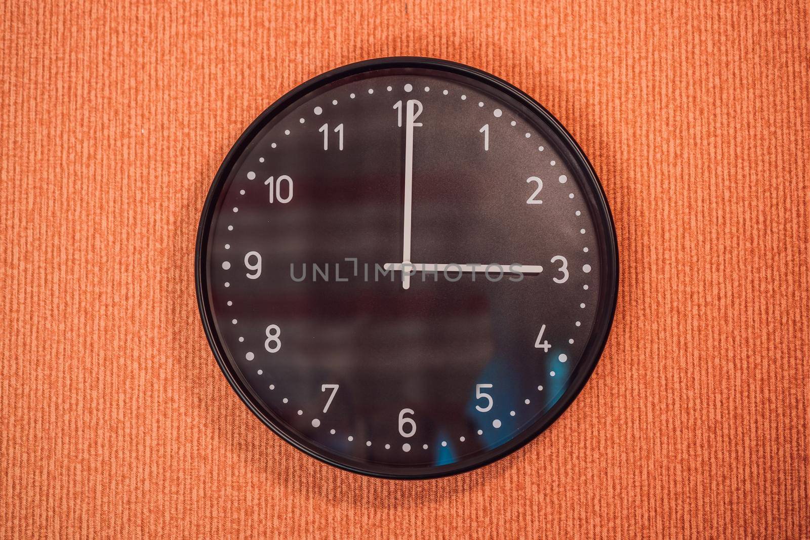 Classic black and white analog clock on red background at One o'clock with copy space by galitskaya