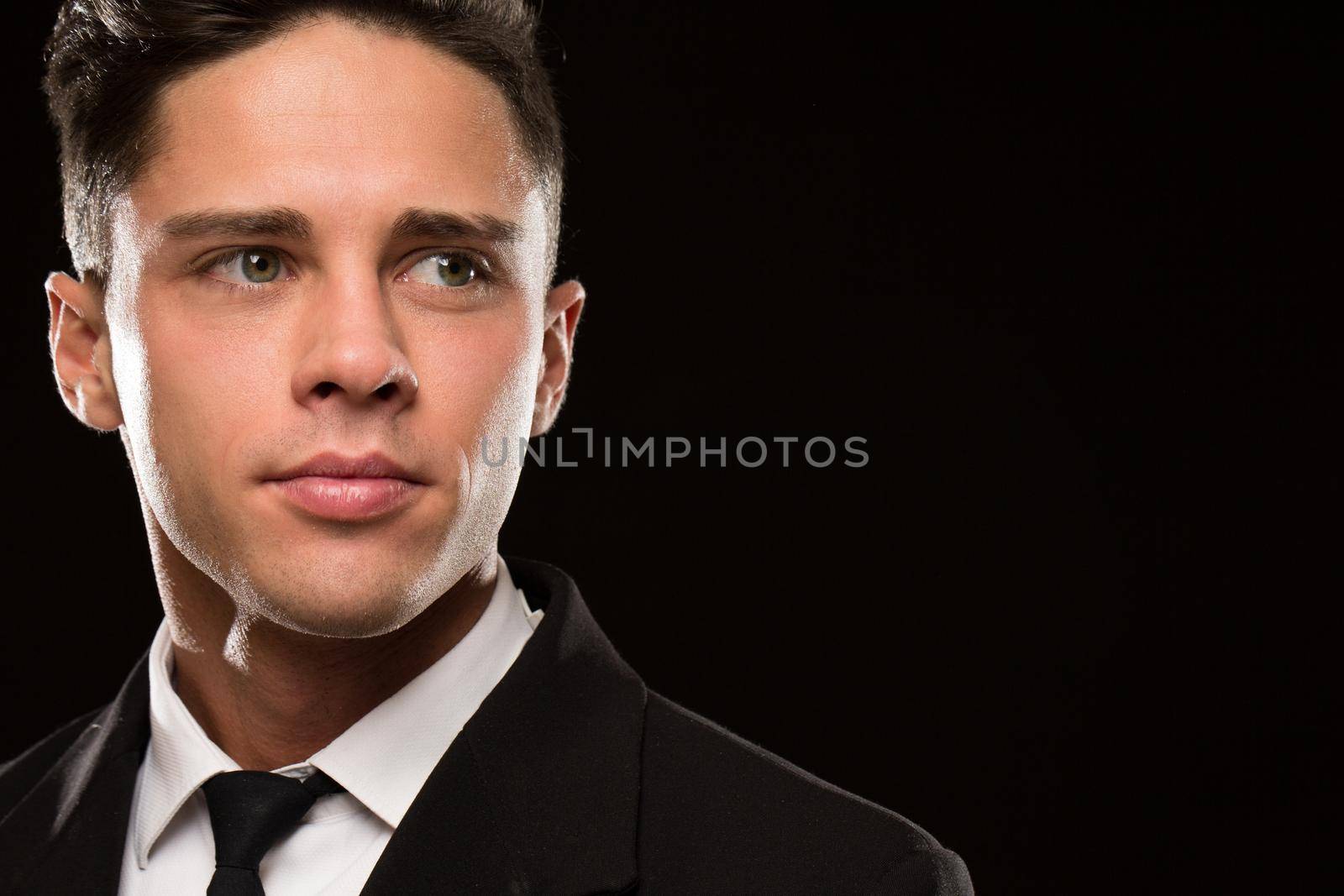 Cropped close up of a handsome young man in a classy suit looking away thoughtfully black background copyspace masculinity confidence businessman success hairstyle sexy seductive expressive