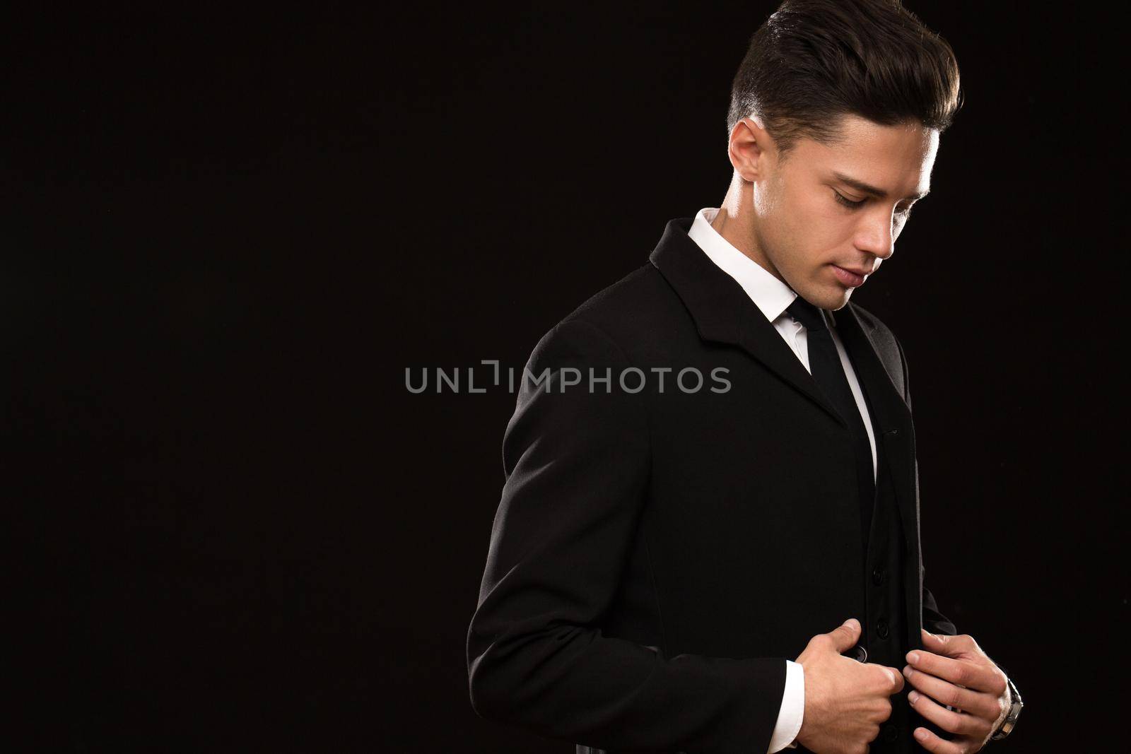 Shot of an elegant young businessman buttoning his jacket on black background copyspace sexy macho masculine handsome luxury lifestyle confidence calm fashion stylish tailoring tailor