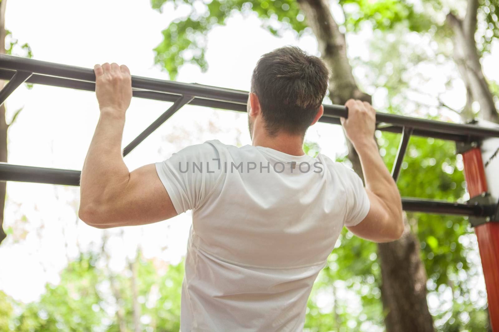 Muscular sportsman working out outdoors by MAD_Production