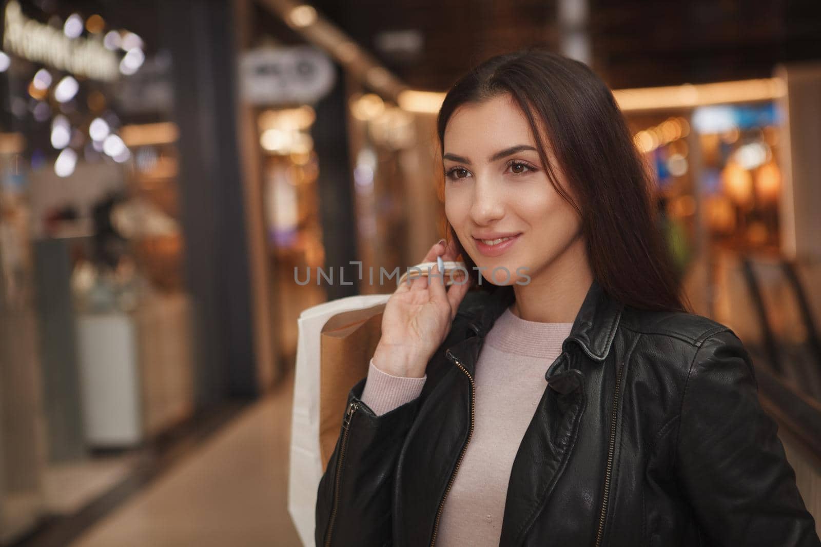 Close up of a beautiful young woman with shopping bags walking at the mall