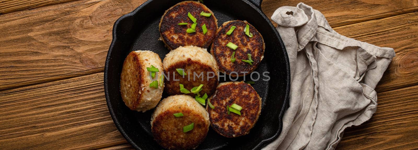 Homemade cutlets from fish, chicken or meat on black cast iron frying pan skillet by its_al_dente