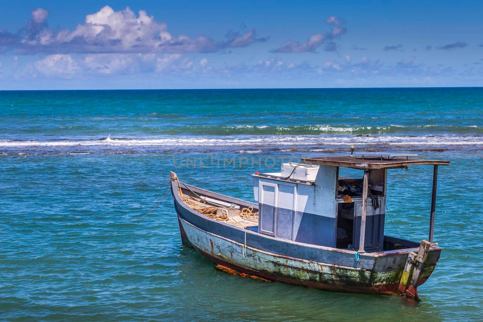 Idyllic Porto Seguro Beach at sunset with fishing trawler in BAHIA, Northeastern Brazil