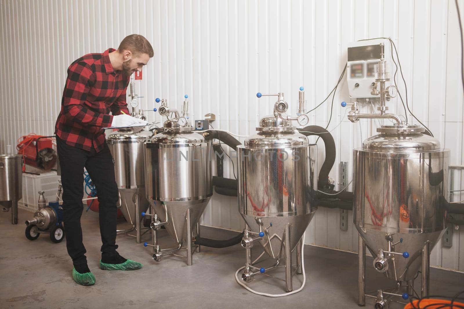 Full length shot of a brewer checking beer tanks at his microbrewery, copy space