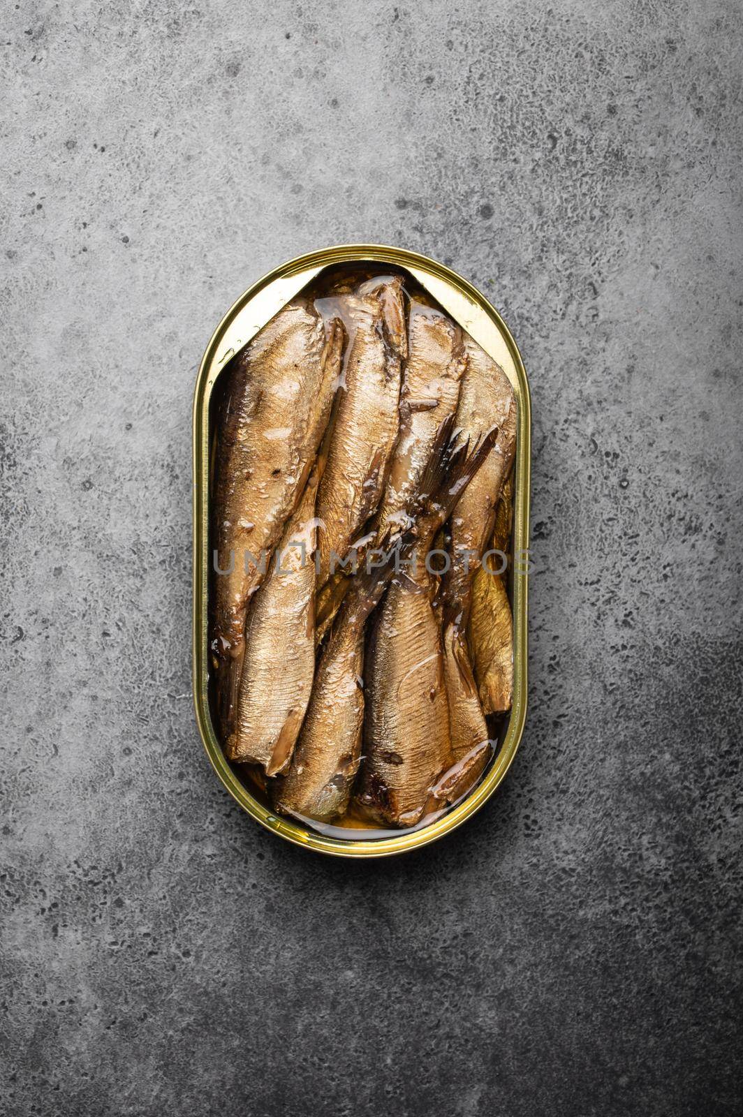 Close up and top view of smoked canned sardine in a tin over gray rustic concrete background. Tinned fish as a convenient, fast, healthy food and source of omega-3 fatty acids, protein and vitamin D