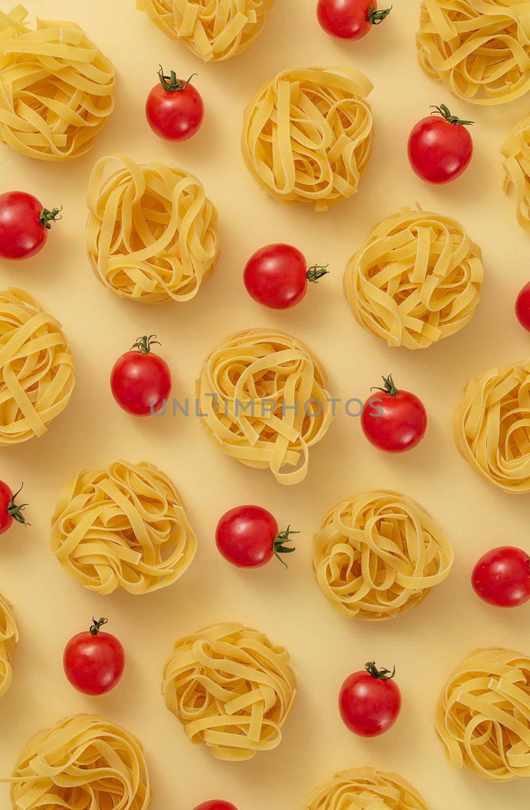 Minimal food pattern of tagliatelle and tomatoes, light yellow pastel background. Traditional Italian pasta in modern pop art style. Pasta and tomatoes, Italian cuisine concept. Top view, flat lay