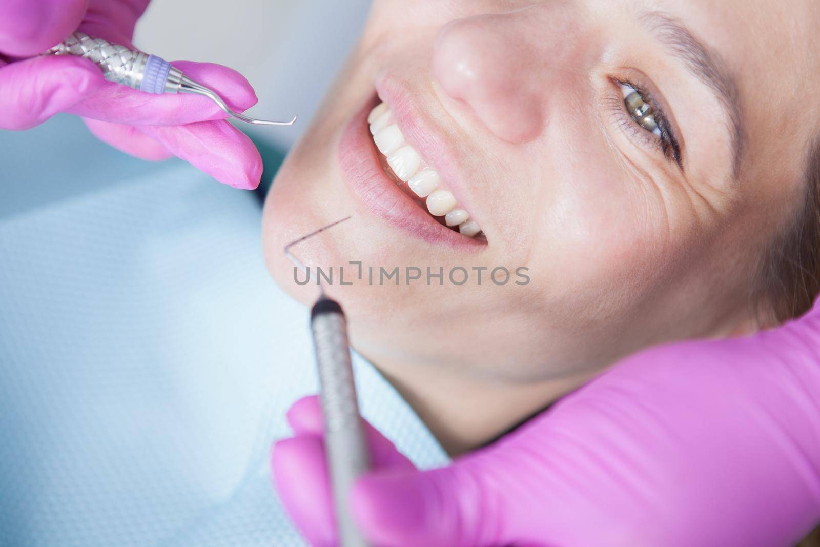 Cropped close up of mature woman smiling with her healthy white teeth during dental examination