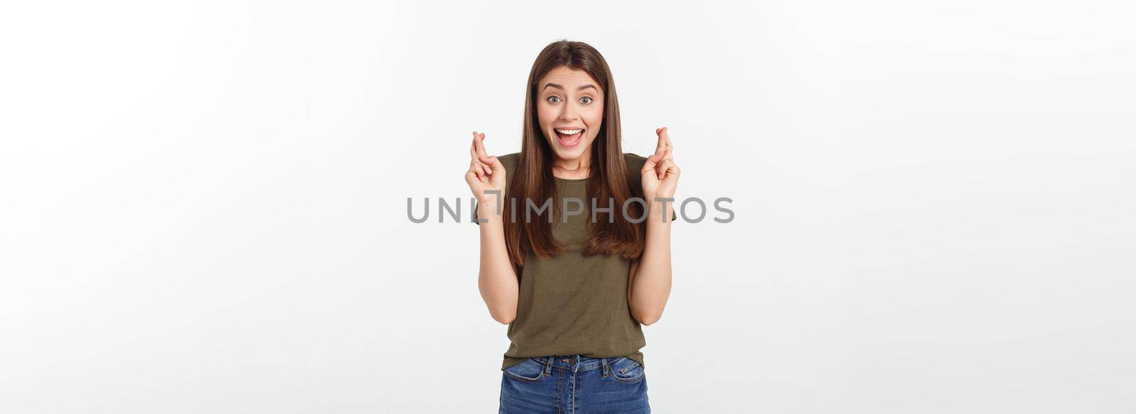 Closeup portrait hopeful beautiful woman crossing her fingers, open eyes, hoping, asking best isolated on gray wall background