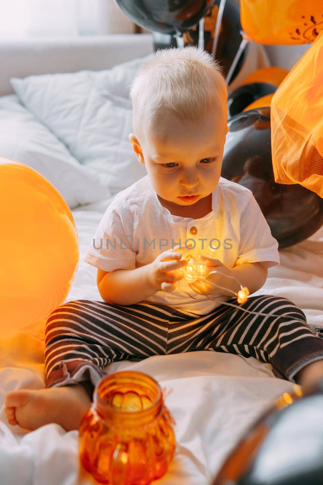 Children's Halloween - a boy in a carnival costume with orange and black balloons at home. Ready to celebrate Halloween by Annu1tochka