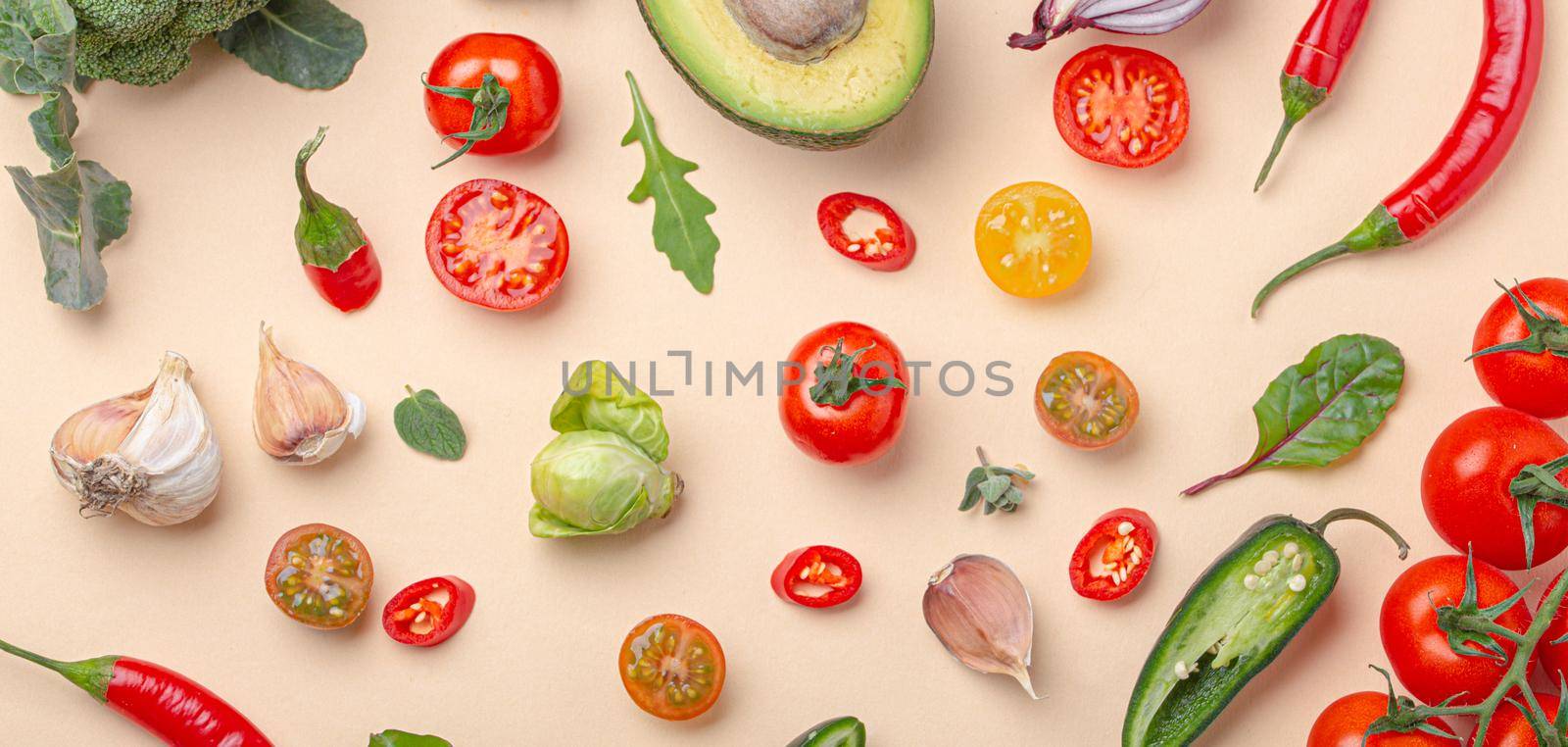 Creative cooking healthy organic food concept background made of colourful fruit and vegetables on beige background flat lay: tomatoes, broccoli, avocado, onion, garlic, herbs top view.