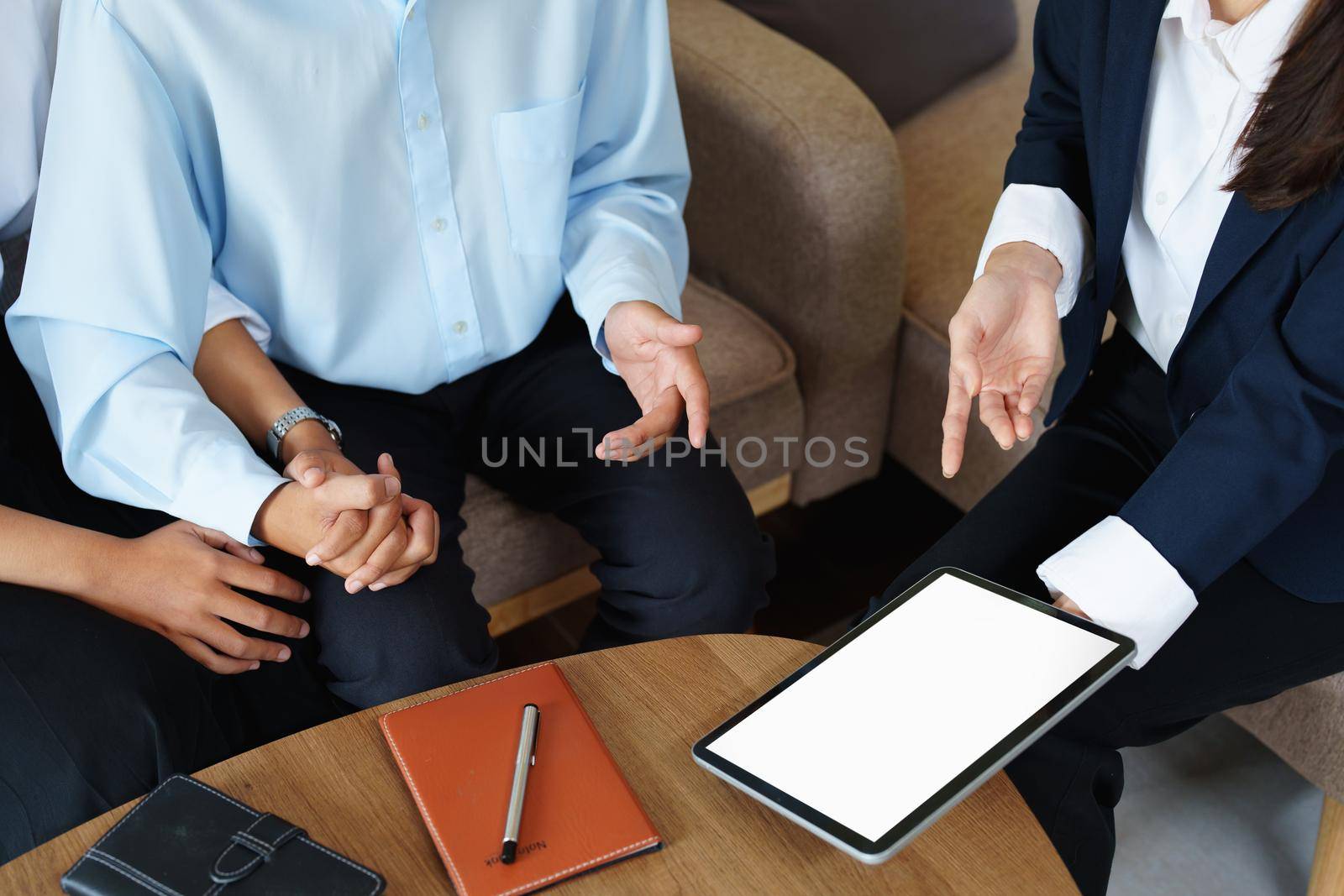 Bank employee holding tablets for customers to see solutions in choosing investments.