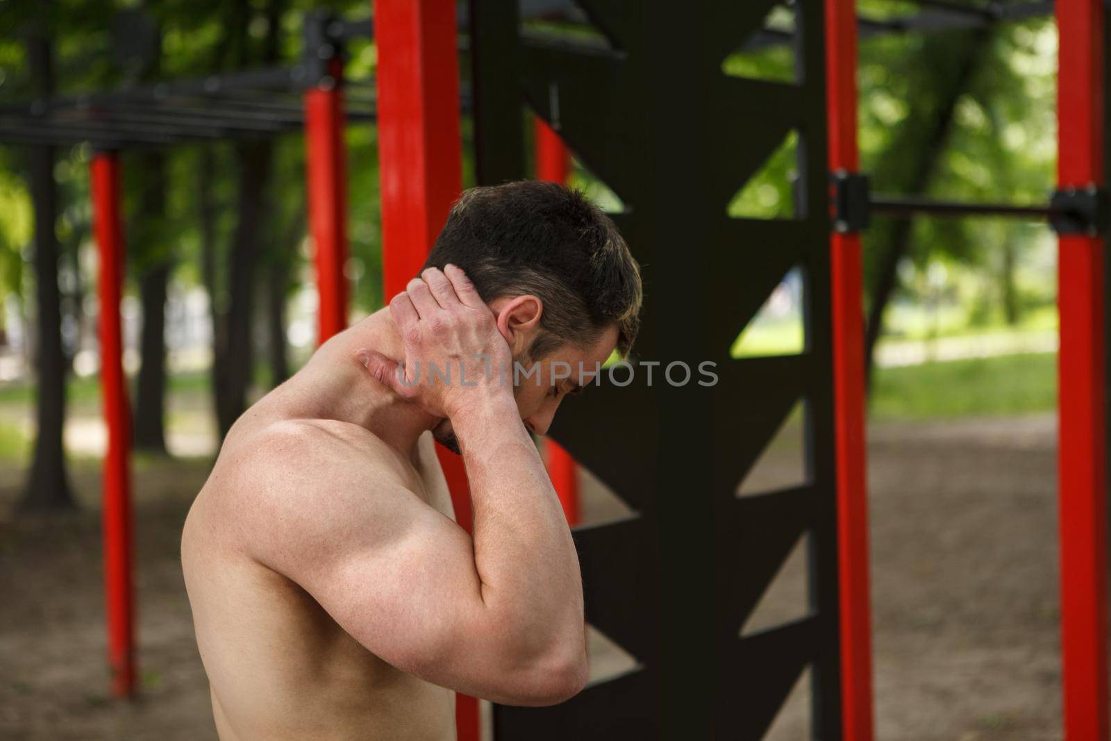 Sportsman having neck pain after exercising outdoors