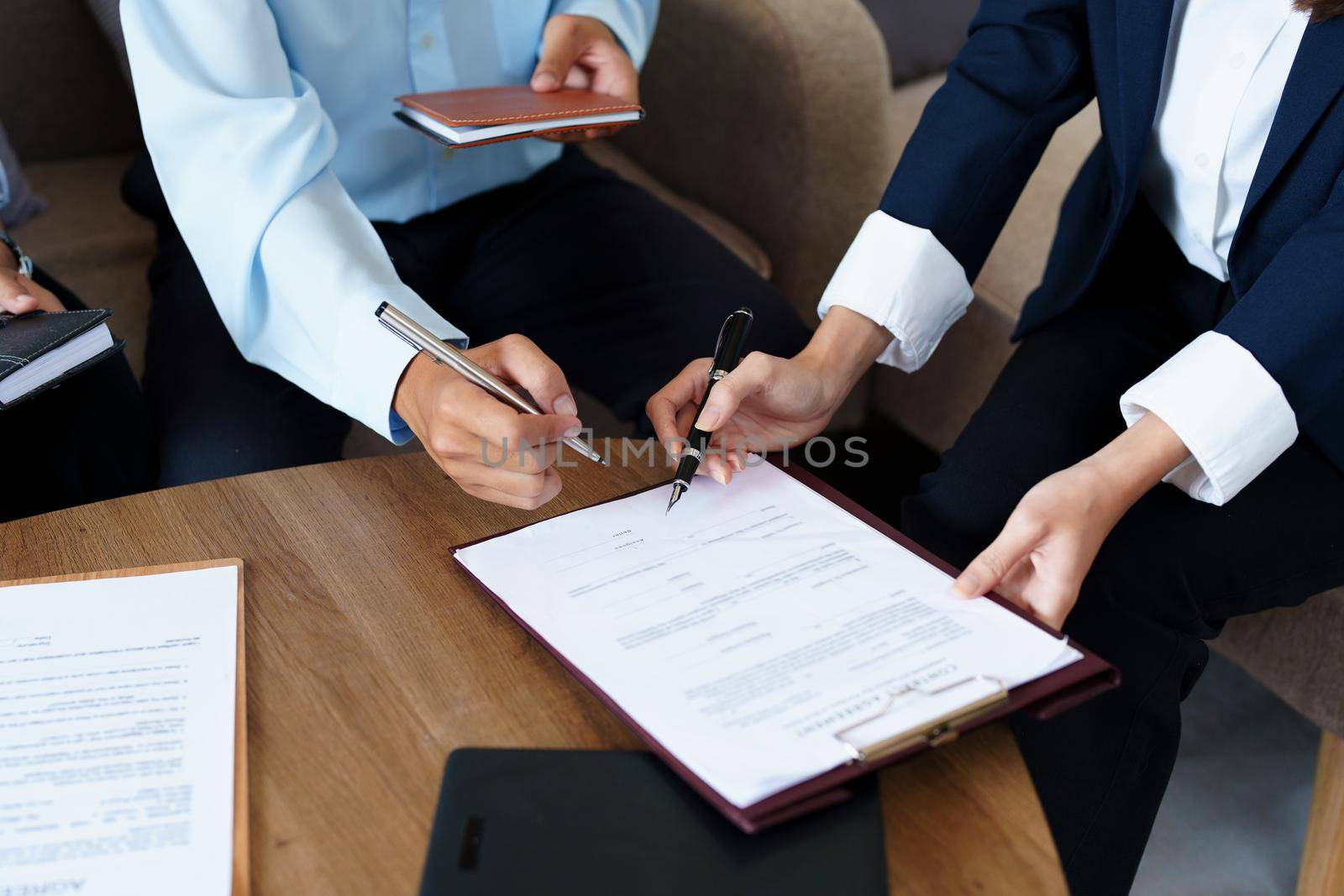 Couples sign important documents with insurance agents.