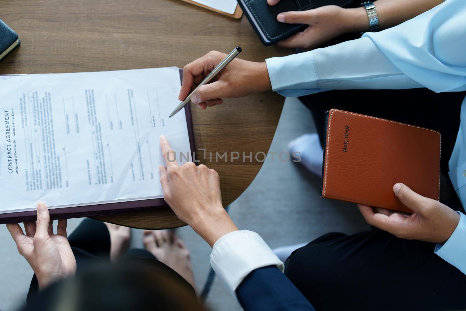 Couples sign important documents with insurance agents.