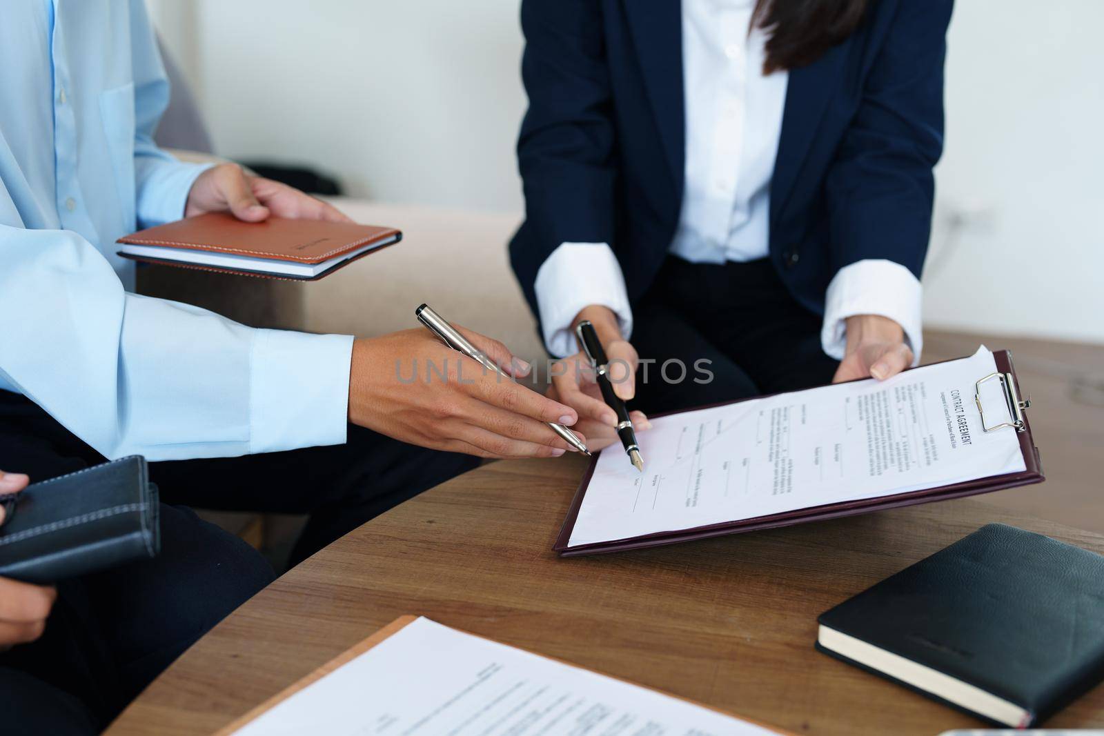 Couples sign important documents with insurance agents.