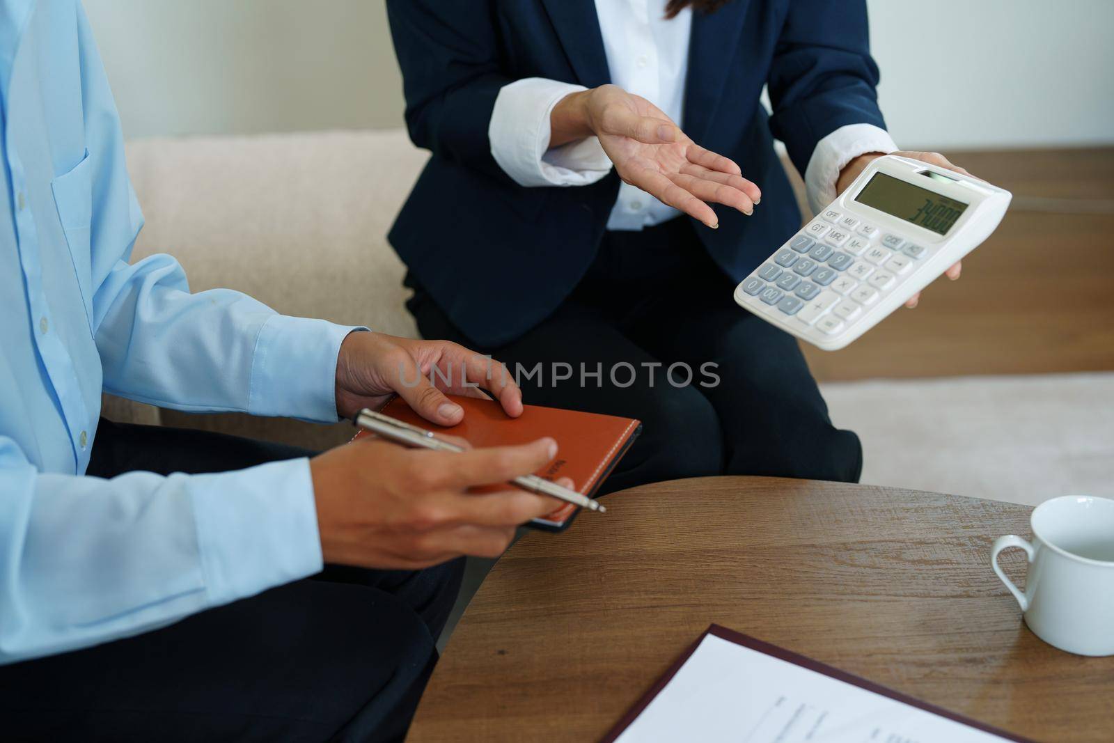 bank employee uses a calculator to calculate loan rates for customers.