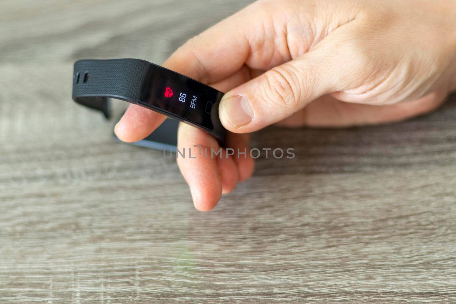 Close up shot of a man setting up a fitness wristband.