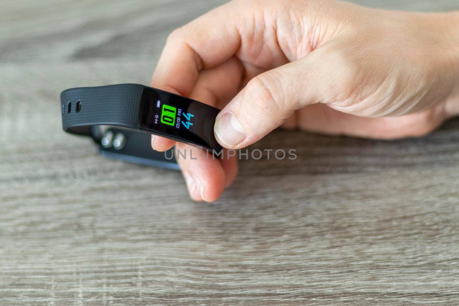 Close up shot of a man setting up a fitness wristband.