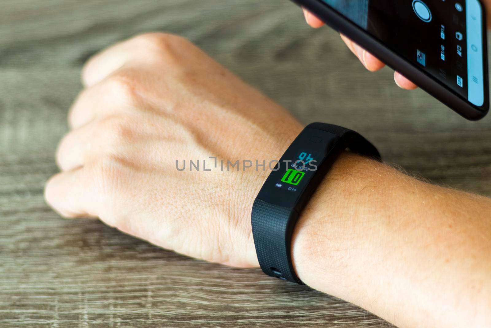 Close up shot of a man setting up a fitness wristband.