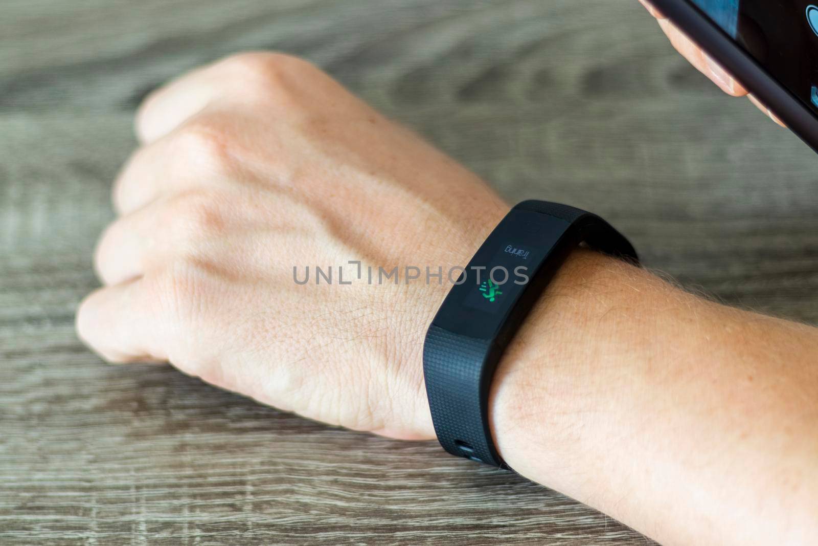 Close up shot of a man setting up a fitness wristband.