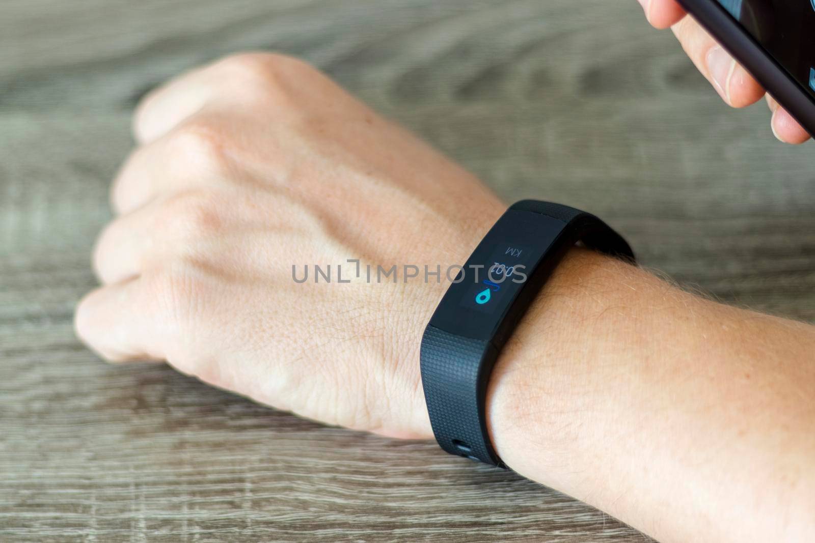 Close up shot of a man setting up a fitness wristband.