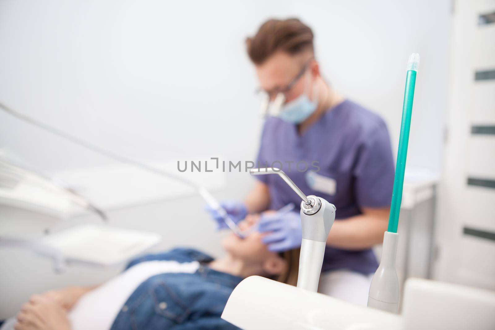 Selective focus on dental equipment, male dentist working with patient on background