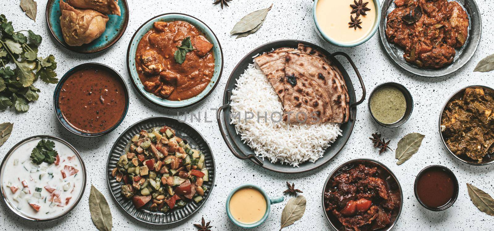 Indian ethnic food buffet on white concrete table from above by its_al_dente