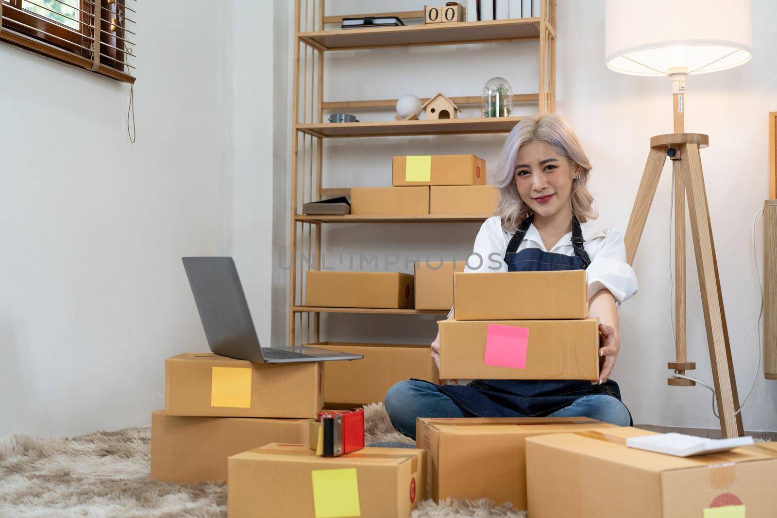 Asian SME business woman with order online shipping parcel boxes at home. Starting Small business entrepreneur SME freelance. Online business, Work at home concept. by nateemee