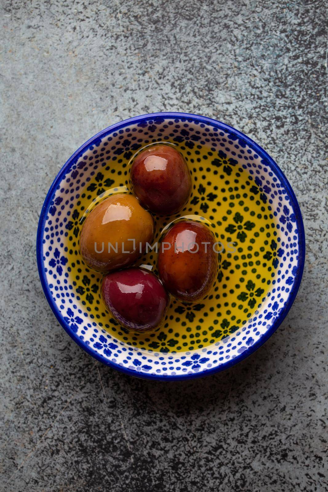 Delicious ripe black olives in a bowl, from above. Middle eastern and Mediterranean traditional snack or appetizer, light and healthy food, top view . by its_al_dente