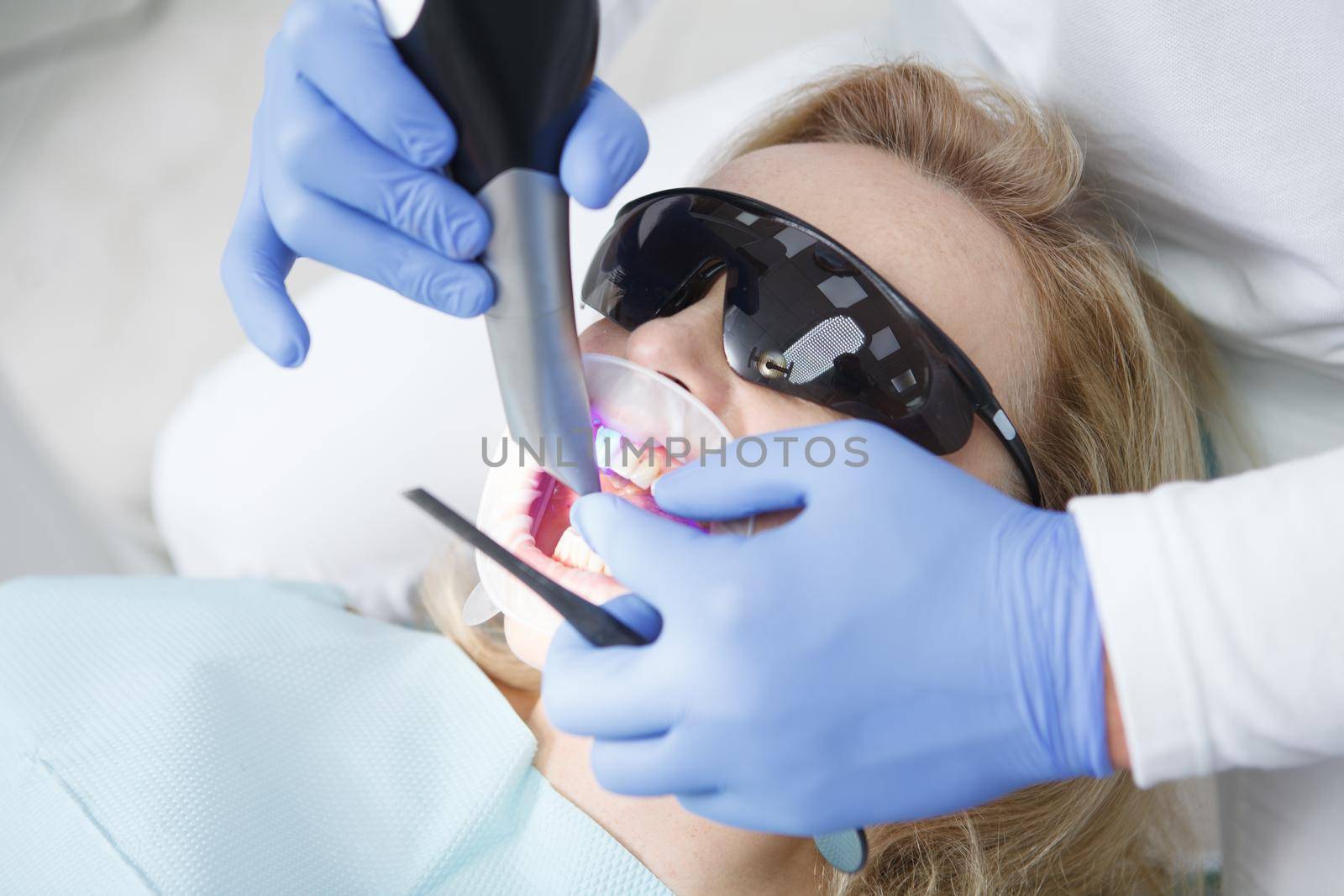 Close up of unrecognizable dentist doing dental scanning of patients teeth
