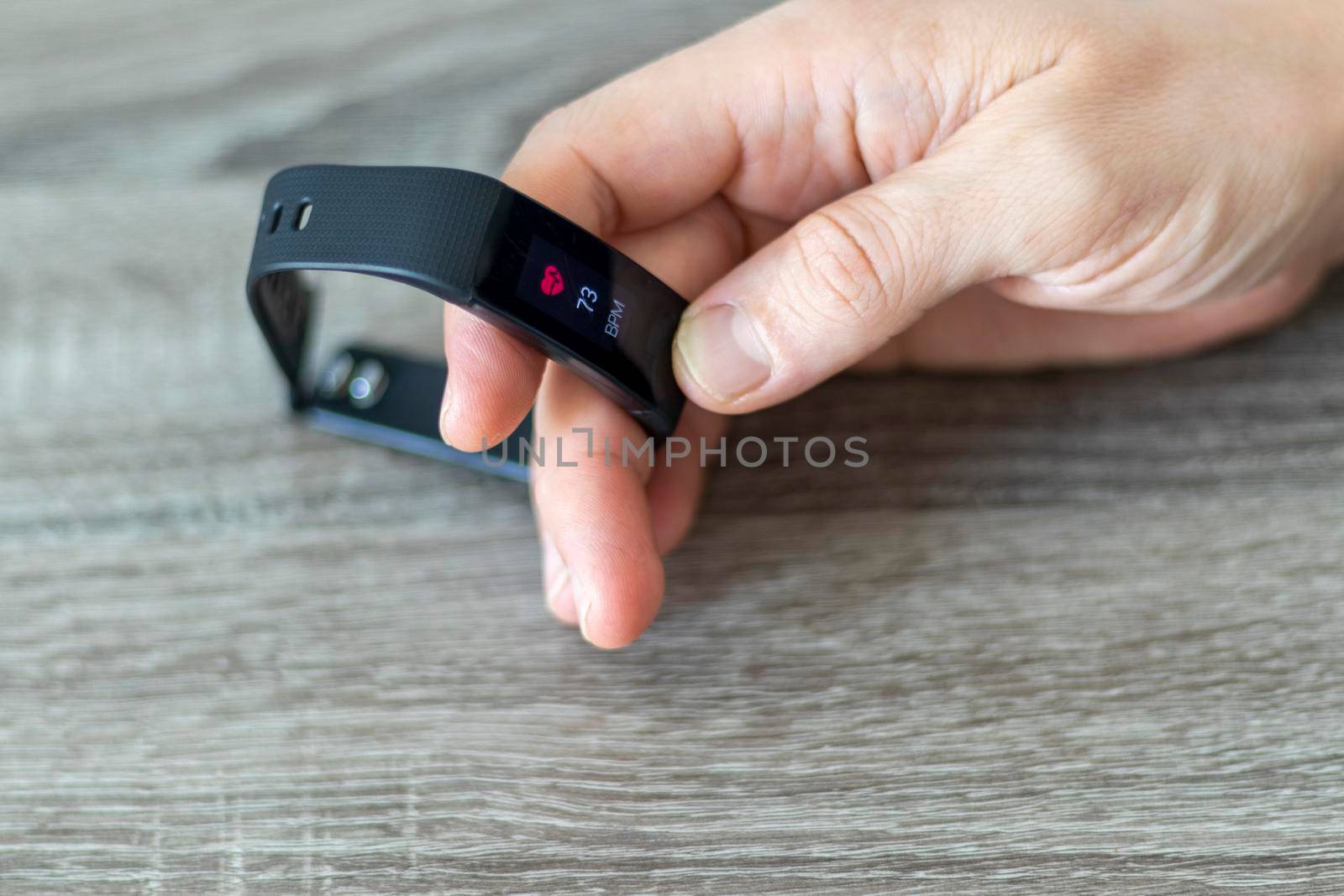 Close up shot of a man setting up a fitness wristband.