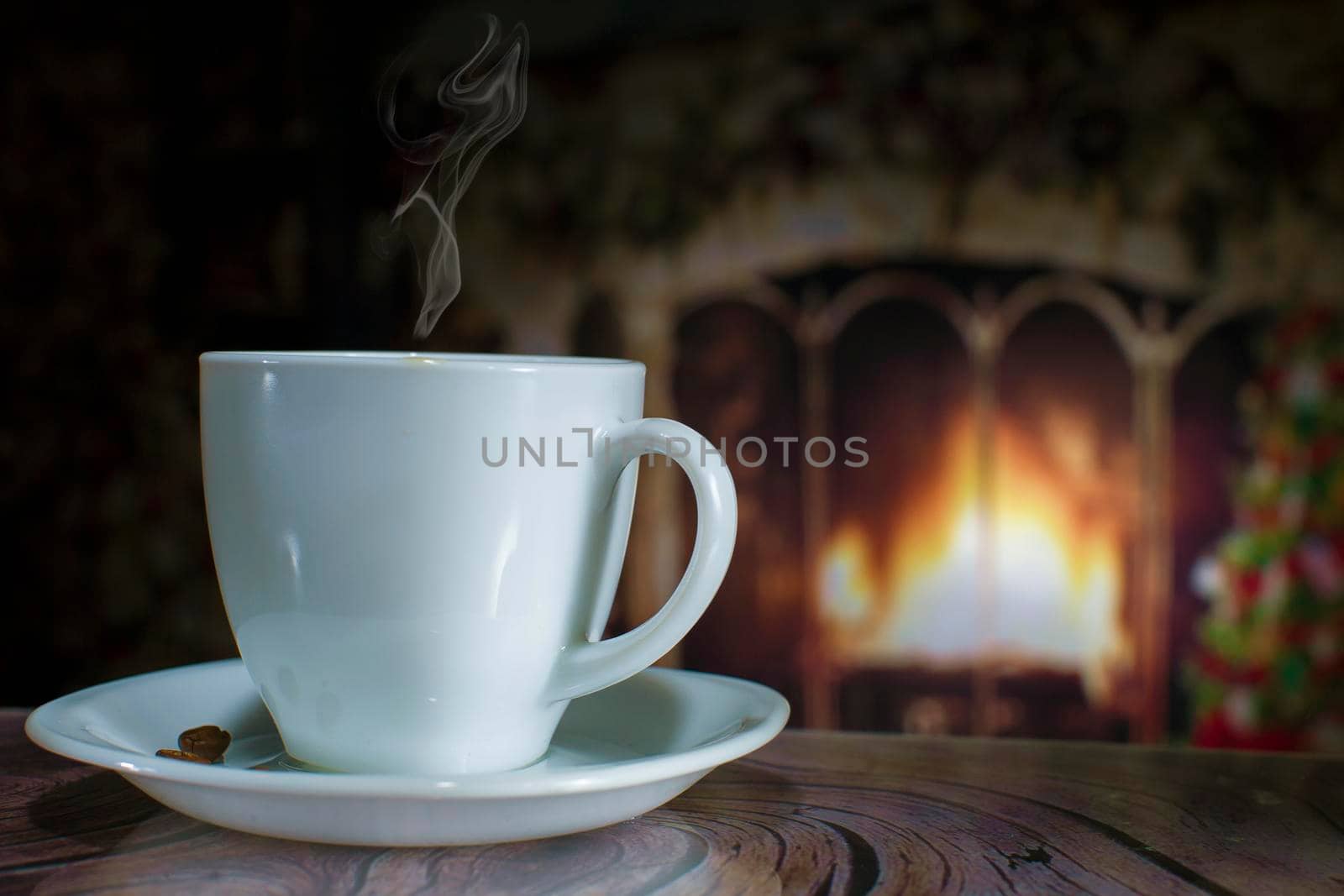 Cup of coffee with smoke on the background of the Christmas fireplace and Christmas tree