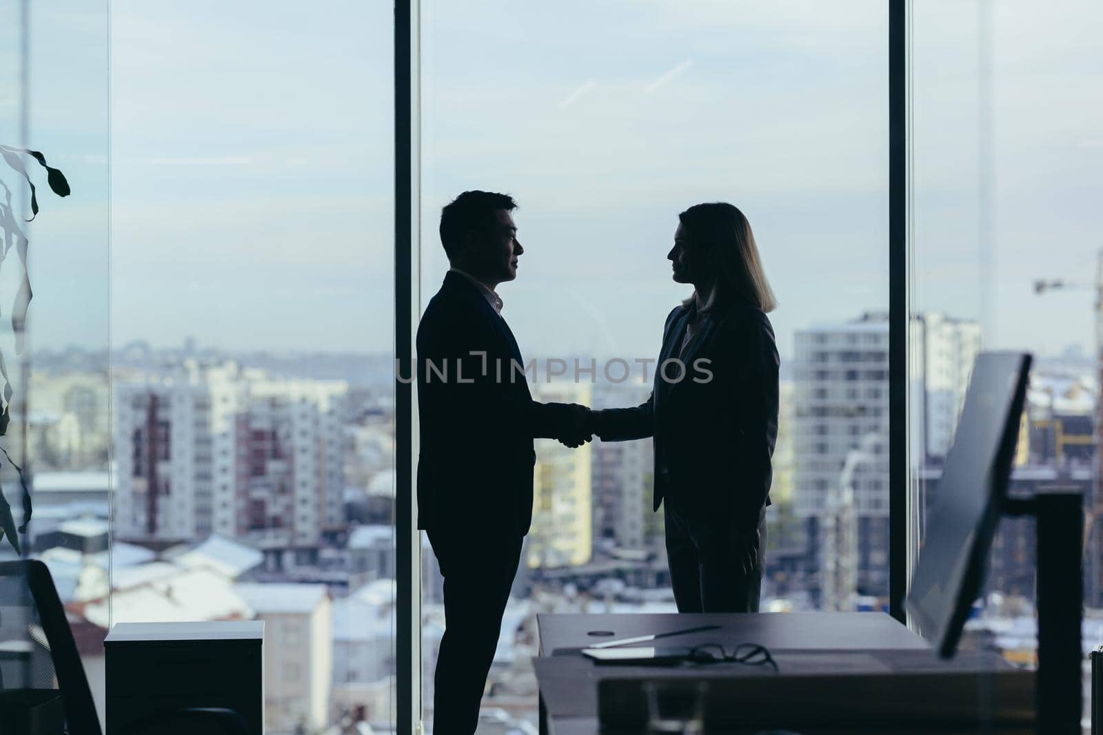 Silhouettes of two employees team of businessmen, Asian man and woman by voronaman