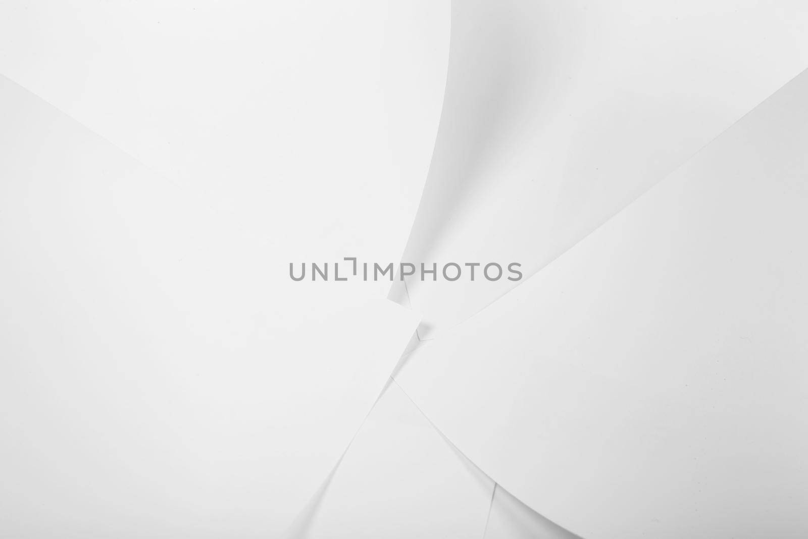 White sheets of office paper are twisted and scattered. Paper white abstract background.