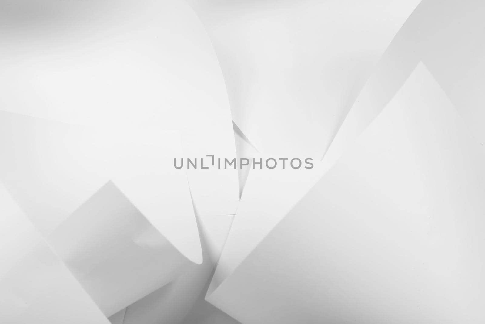 White sheets of office paper are twisted and scattered. Paper white abstract background.