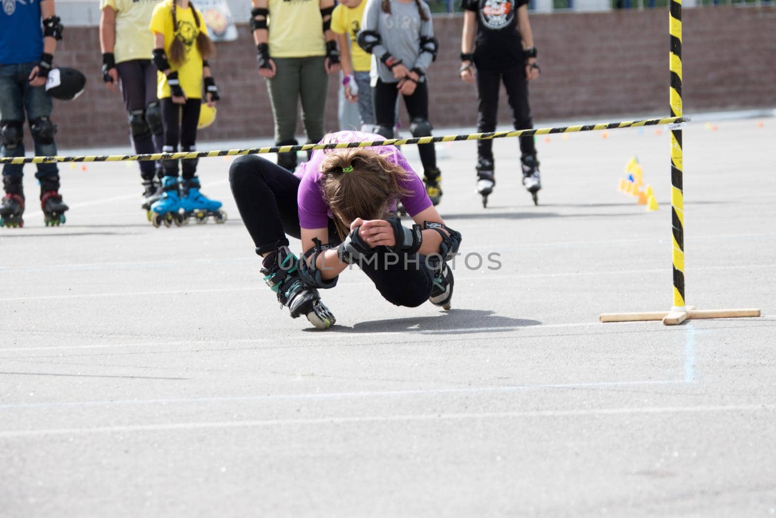 Competition in roller sport.An athlete on roller skates rides under the barbell