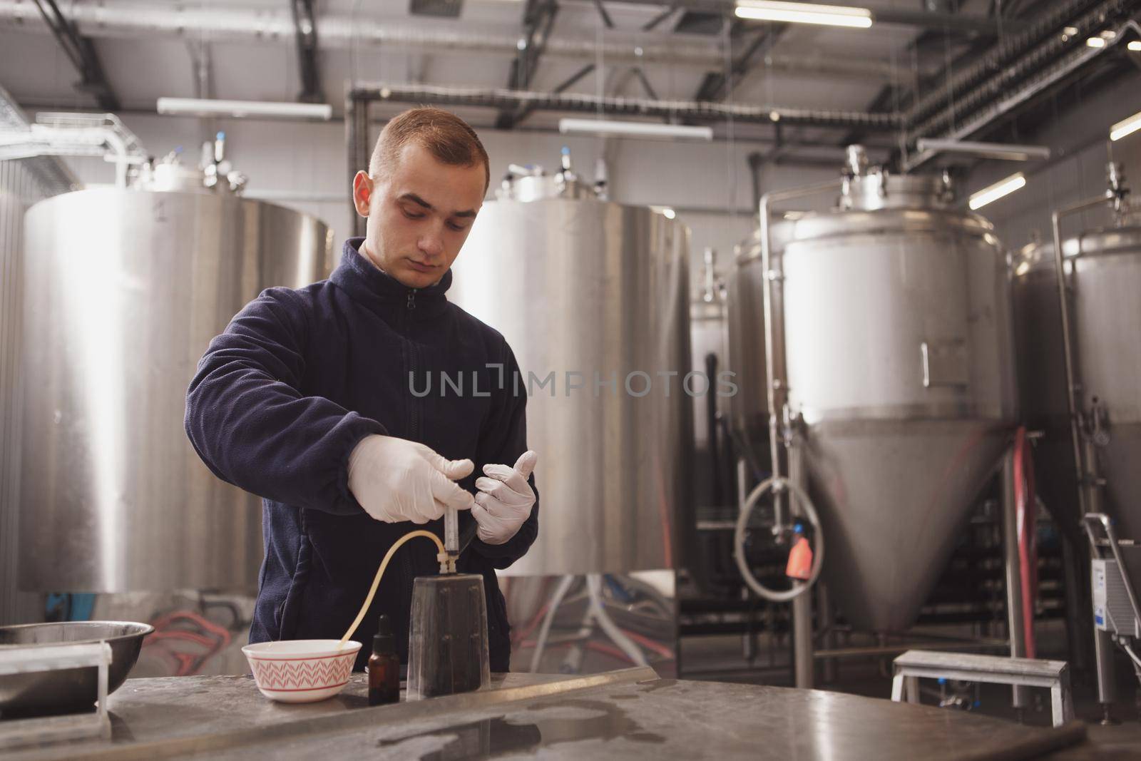 Brewer checking quality of beer at his beer factory, copy space