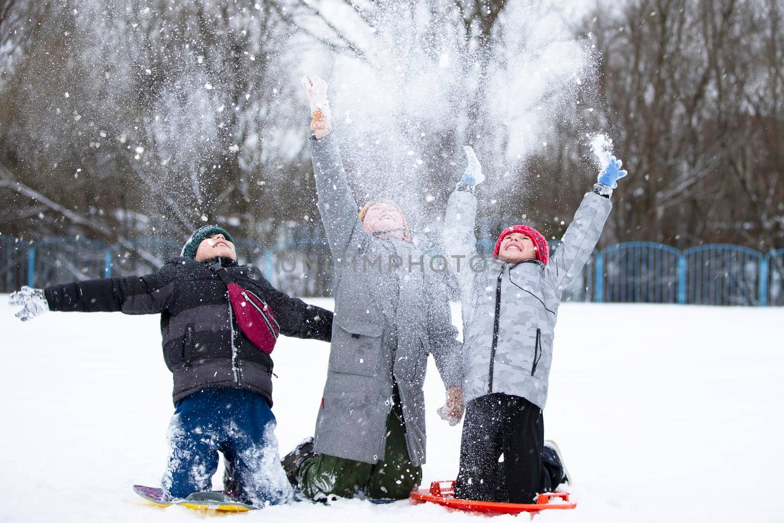 Children in winter. Three little boy friends are playing in the snow. by Sviatlana