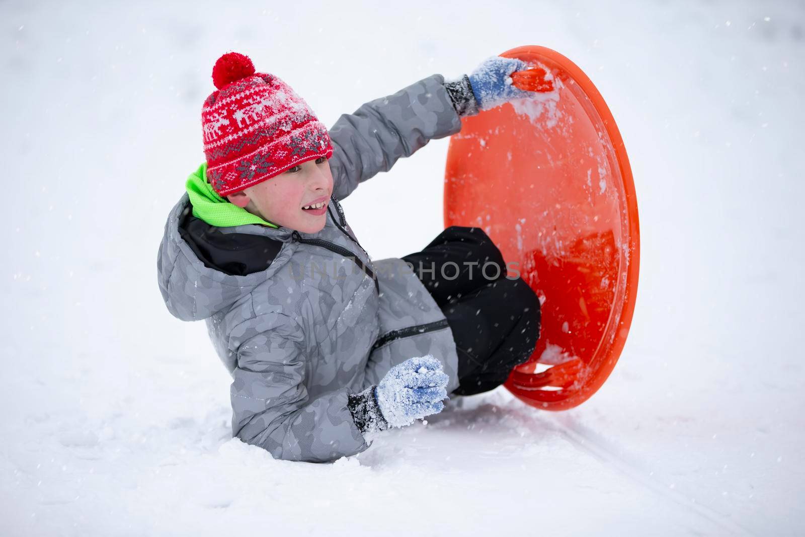 Child in winter. The boy is sledding.
