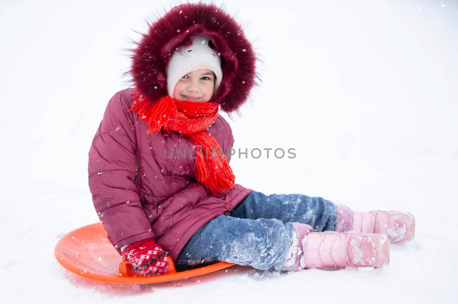 Child in winter. The girl is sledding. by Sviatlana