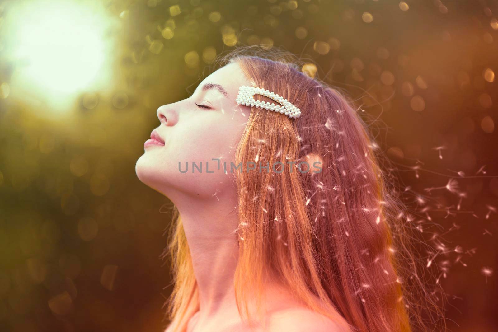 Beauty model girl profile with flying dandelions. Beautiful young woman with long romantic hair.