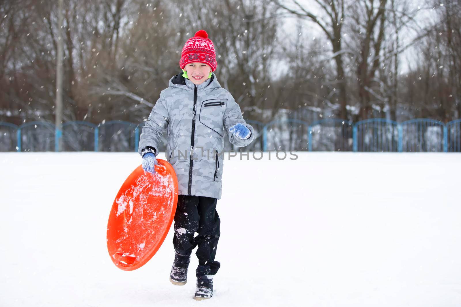 Child in winter. The boy is sledding.