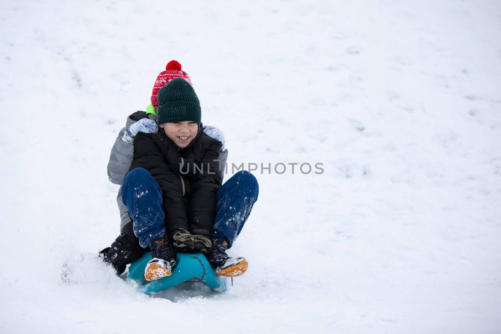 Children in winter. Boys friends are sledding.
