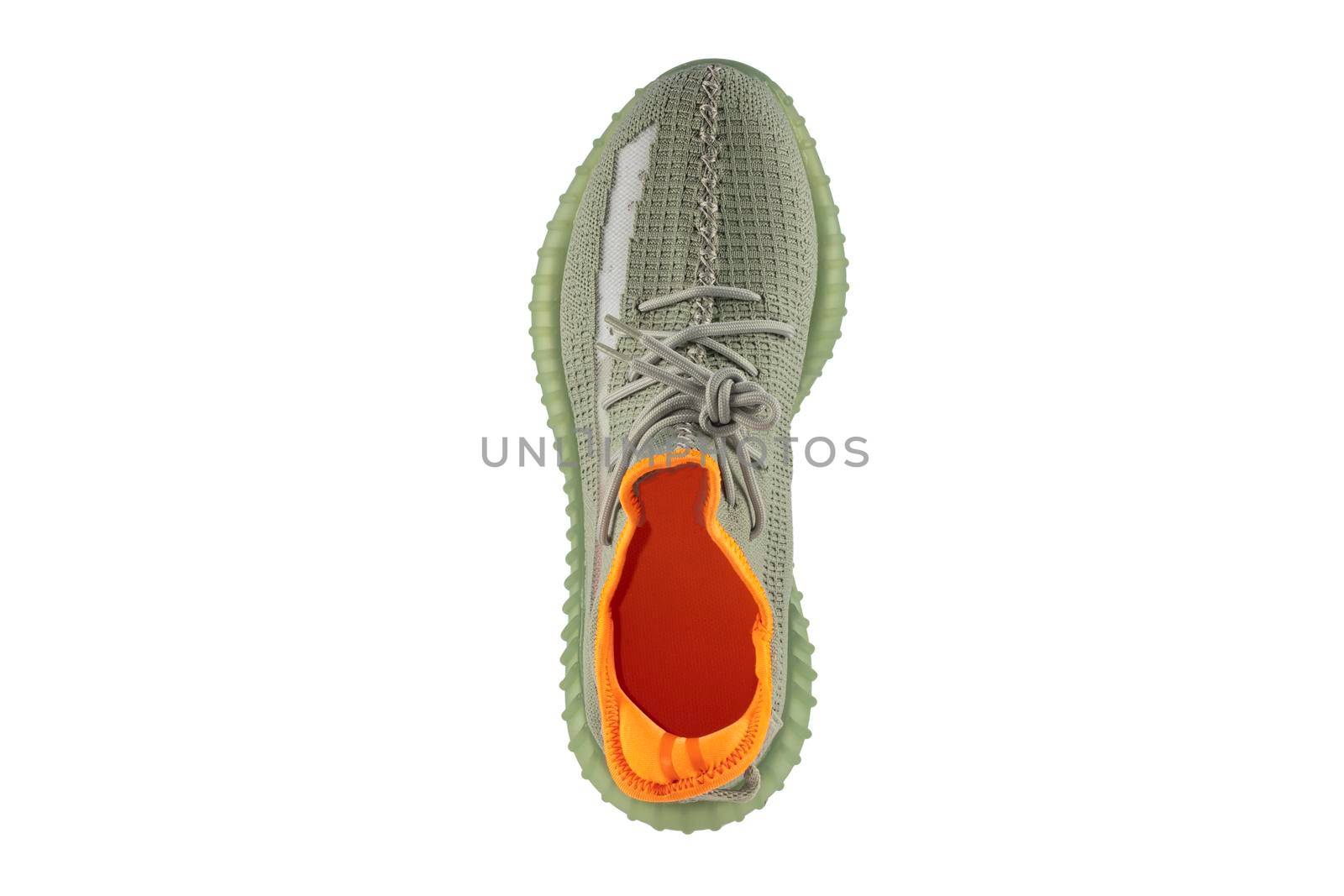 Green rag sneaker isolated on white background. Cheap sports shoes.