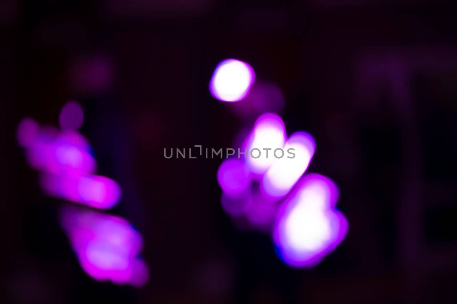 Purple and white spots of large bokeh on a black background.