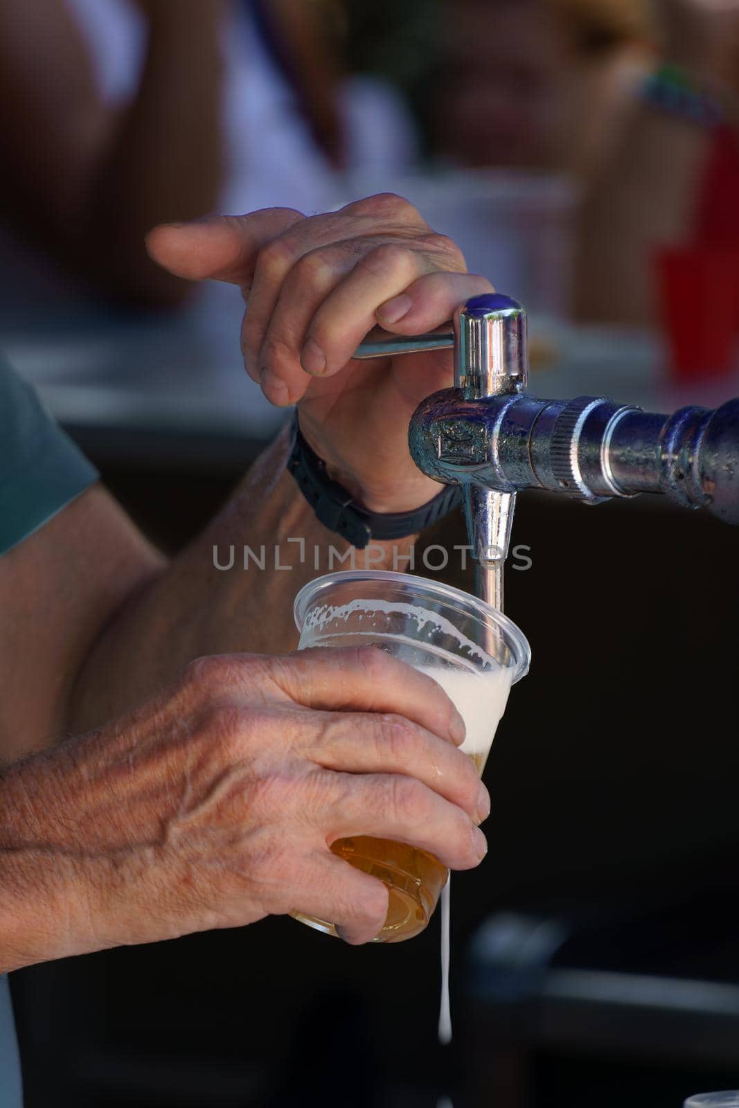 close-up of a man pouring a draught beer with foam