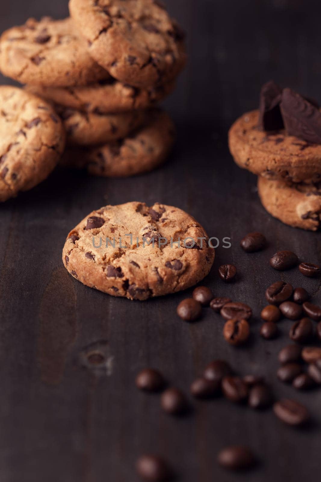 Chocolate chip cookies on old wooden table with coffee beans. Homemade snack.
