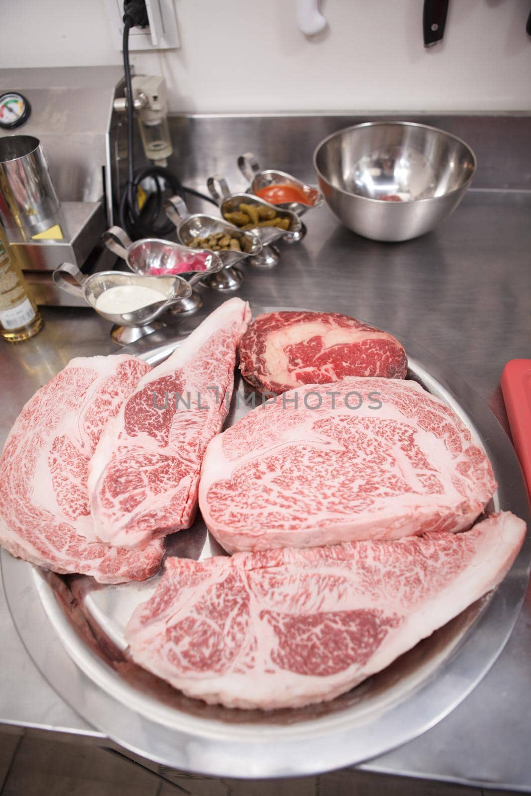 Vertical close up of fresh raw marbled beef steaks on a plate