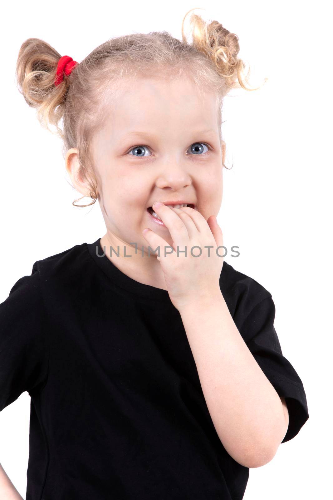 Funny little girl put her fingers in her mouth. The child is four years old. Little blonde girl smiles.