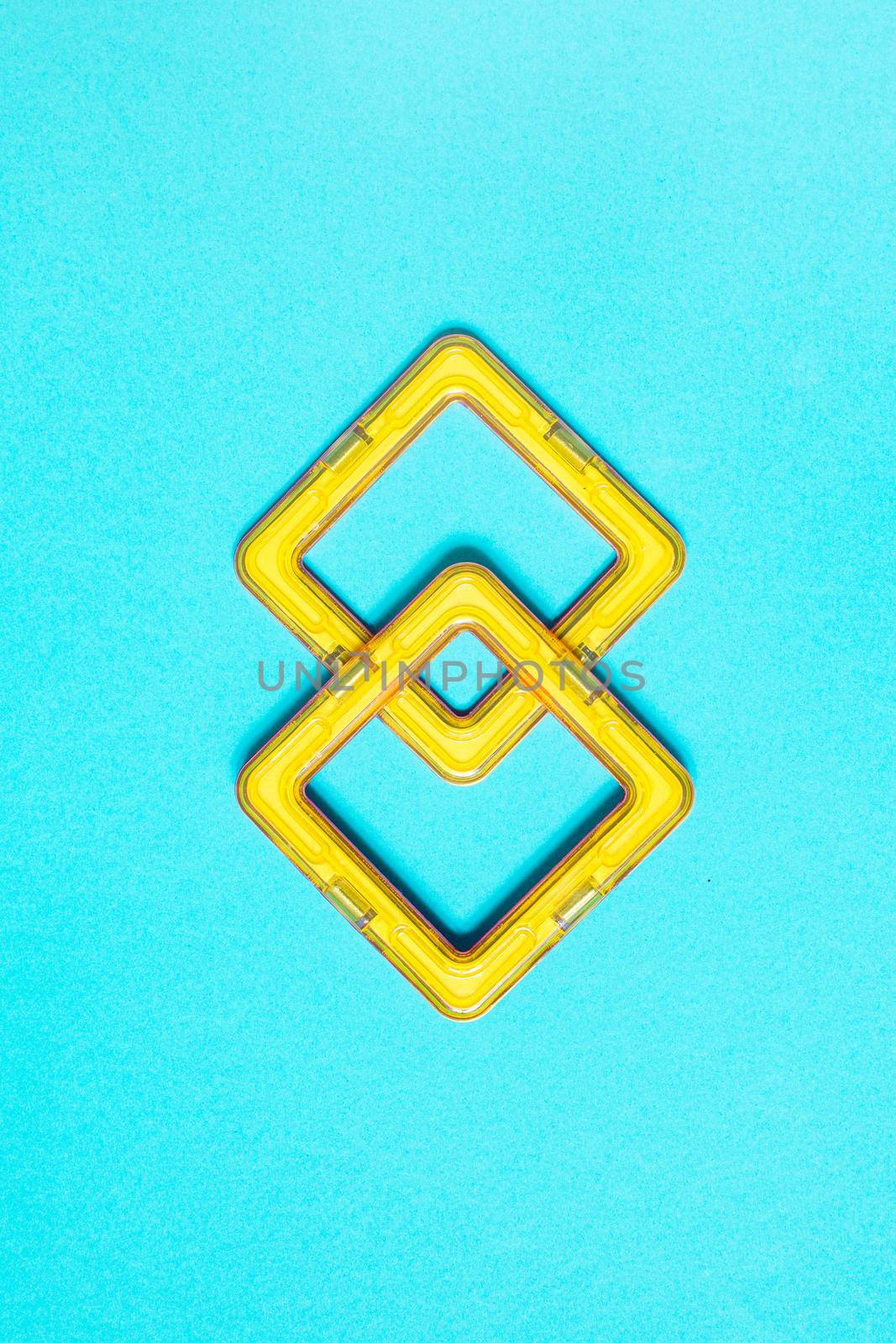 Constructor children plastic yellow colored on a pastel blue by Ciorba